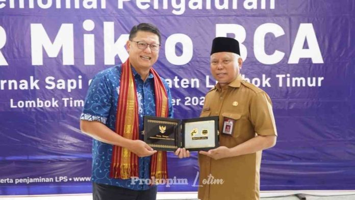 Foto : Bupati Lotim HM Sukiman Azmy menerima cinderamata dari Direktur BCA (dok:ist)