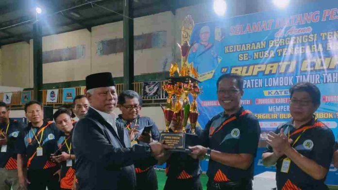 Foto : Bupati Lombok Timur HM Sukiman Azmy saat menyerahkan Piala Bupati Cup kepada ketua Umum PTMSI Lotim, HM Juaini Taofik (dok:arul/ PorosLombok)