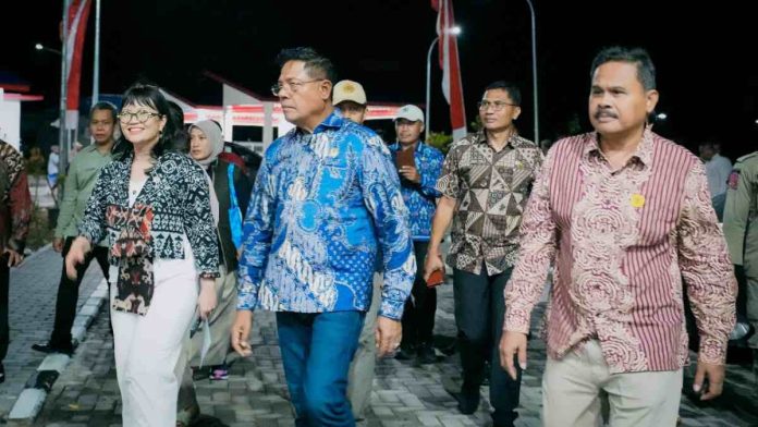 Logopit_1770955608559 Wamen Stella Christie berbaju batik hitam putih dan Bupati Haerul Warisin berkemeja batik biru berjalan bersama rombongan saat peresmian pusat riset rumput laut di Lombok Timur pada malam hari.