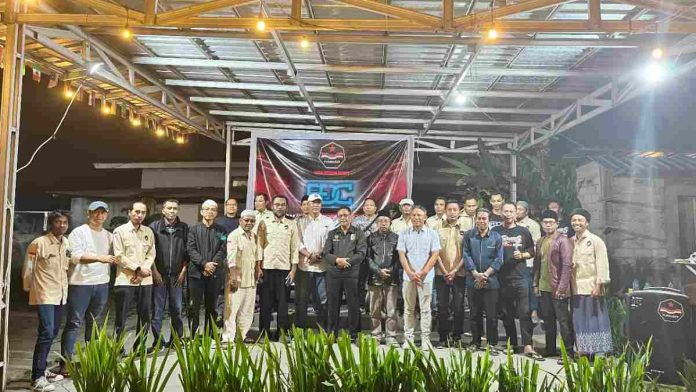 Logopit_1771212671237 Kelompok pria berdiri di depan spanduk FDC saat acara diskusi publik UU Desa di Lombok Timur.