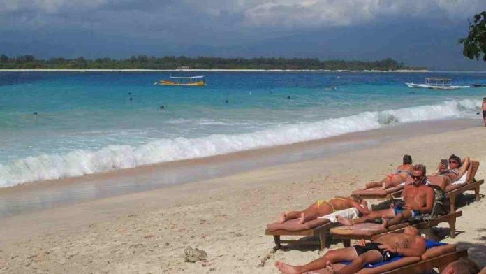 Gili terawangan Wisatawan asing di pantai Gili Trawangan Lombok Utara lokasi pemberlakuan aturan tirai restoran selama Ramadhan.