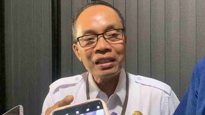 Asisten I Setda Kota. JPg Asisten I Setda Kota Mataram Lalu Martawang berbaju dinas putih sedang berbicara di depan wartawan.