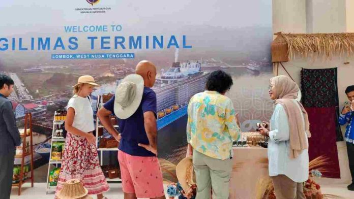 Gilimas. JPG. Wisatawan asing di Pelabuhan Gili Mas sedang melihat gerai produk UMKM lokal dengan latar belakang spanduk