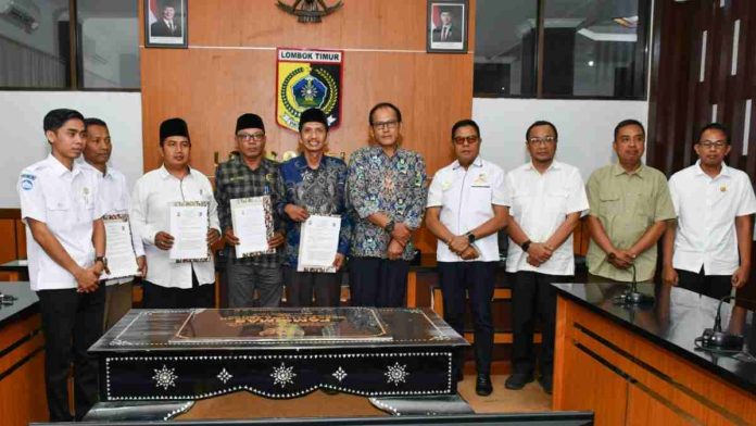 Bupati Lombok Timur H. Haerul Warisin bersama jajaran pejabat dan kepala desa berfoto bersama sambil memegang dokumen berita acara serah terima program Pamsimas 2025.