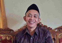 Ramadan Berkah BAZNAS Lombok Utara Kucurkan Bantuan untuk Ratusan Mustahik Foto close-up Ketua BAZNAS Lombok Utara, Selamet Riyadi, mengenakan kemeja batik cokelat dan peci hitam, sedang tersenyum saat memberikan keterangan terkait penyaluran bantuan zakat.