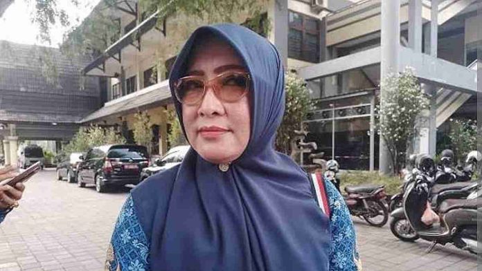 Baiq Nelly Kusumawati mengenakan jilbab biru dan seragam batik, memberikan keterangan pers tentang larangan fasilitas dinas untuk kepentingan pribadi di kantor Pemkot Mataram.