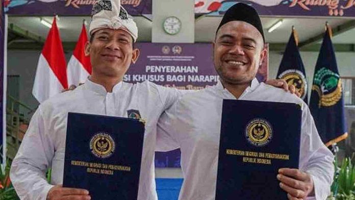 Dua warga binaan Lapas Lombok Barat tersenyum memegang map biru berisi surat keputusan remisi khusus dari Kemenkumham.
