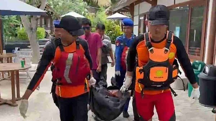 Petugas SAR mengenakan rompi pelampung oranye sedang menggotong kantong jenazah hitam berisi jasad WNA Inggris di area dermaga Gili Air.