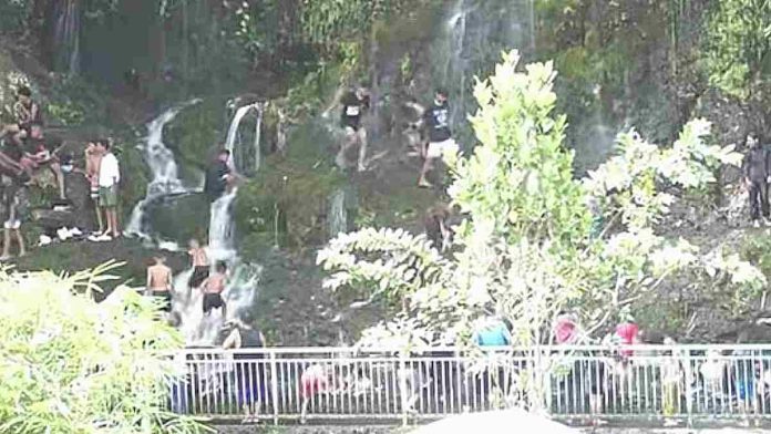 Rombongan wisatawan anak-anak dan dewasa sedang asyik bermain air dan berenang di aliran air terjun alami bertingkat di pemandian alam Pancor Kopong Lombok Timur yang ramai dikunjungi saat libur Lebaran Topat.
