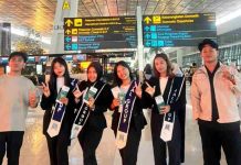 6 Pemuda Berangkat ke Jepang PT ARK Jinzai Perkuat Kemitraan 15 Tahun Foto bersama enam orang pemuda-pemudi Indonesia, calon tenaga kerja PT ARK Jinzai, di terminal keberangkatan bandara. Empat wanita mengenakan selempang bertuliskan logo perusahaan dan memegang paspor.