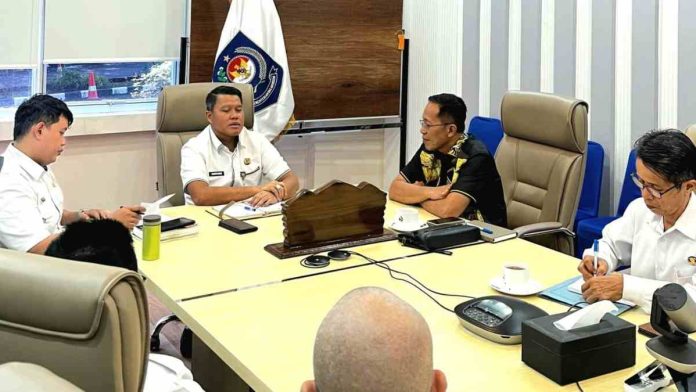 Pertemuan formal antara Sekda Lombok Timur dengan pejabat kementerian di sebuah ruang rapat, membahas koordinasi regulasi pemerintahan desa.