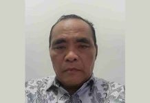 Kenaikan IPM Lombok Timur Dipicu Kebijakan Strategis Dikbud Lotim Foto close-up Dr. H. Lalu Moh. Fahri, MH mengenakan kemeja batik bermotif flora dengan latar belakang dinding putih polos, menatap ke arah kamera dengan ekspresi formal.