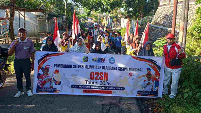 Sekelompok siswa dan guru berdiri di jalan aspal sambil memegang spanduk besar bertuliskan 