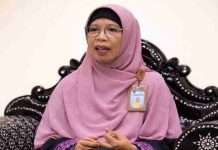 RS Mutiara Sukma Perluas Layanan Kesehatan Ibu Anak dan Kebugaran di NTB Seorang wanita berhijab pink dan berkacamata duduk di kursi ukir hitam. Ia mengenakan kartu identitas pegawai dan tampak sedang memberikan penjelasan dalam sesi wawancara.