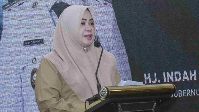 Wakil Gubernur NTB Hj. Indah Dhamayanti Putri mengenakan jilbab cokelat sedang berdiri memberikan sambutan di podium pada acara resmi pemerintahan.