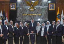 Sinta Agathia Pimpin YKI NTB Serukan Gerakan Massal Lawan Kanker Melalui Kolaborasi Elemen Warga Sekelompok pengurus YKI NTB mengenakan seragam jas hitam dan hijab abu-abu berpose bersama di depan lambang Garuda Pancasila dan tulisan Nusa Tenggara Barat.