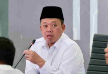 Menteri Nusron Wahid Targetkan Nol Berkas Layanan Pertanahan Akhir Mei 2026 Foto close-up Menteri Nusron Wahid mengenakan kemeja putih dan peci hitam sedang berbicara serius sambil memegang mik dalam sebuah rapat pimpinan.