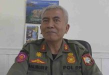 Pemda Lombok Timur Ultimatum Pengusaha Besar yang Rampas Jatah Gas LPG 3 Kg Rakyat Miskin Potret Kasat Pol PP Lombok Timur Salmun Rahman mengenakan seragam dinas PDL cokelat lengkap dengan atribut pangkat, sedang duduk memberikan penjelasan.