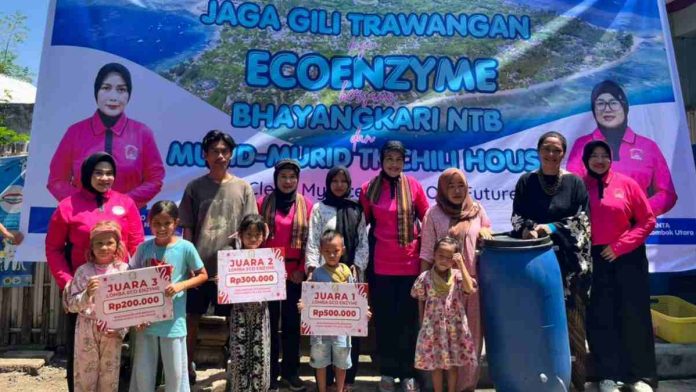 Sekelompok warga dan anak-anak binaan Chili House berpose bersama pengurus Bhayangkari di depan spanduk kegiatan 