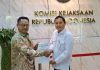 Pengacara Terdakwa Pokir DPRD NTB Adukan Kejati ke Komjak dan DPR RI Dua pria berdiri bersalaman sambil memegang dokumen surat laporan resmi di depan dinding marmer bertuliskan Komisi Kejaksaan Republik Indonesia dengan logo emas.