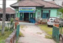 Pejabat Definitif Tak Ada, Administrasi Nikah di KUA Masbagik Semrawut Tampak depan bangunan Kantor Urusan Agama (KUA) Masbagik berwarna hijau dengan spanduk program pemerintah di bagian atas dan sebuah mobil terparkir di halaman.