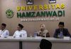 Universitas Hamzanwadi Go Global, Belasan Mahasiswa Pariwisata Berangkat Magang ke Jepang Empat orang duduk di meja panjang saat konferensi pers. Seorang wanita berhijab di tengah berbicara memegang mikrofon, didampingi tiga pria berpeci. Latar belakang dinding tertulis UNIVERSITAS HAMZANWADI.