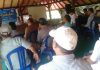 88 Kades Purna Tugas di Lombok Timur Siap Bertarung Lagi pada 2026 Suasana pertemuan di aula terbuka beratap kayu (gazebo besar). Peserta yang merupakan pria mengenakan topi dan kemeja duduk membelakangi kamera menghadap narasumber.