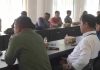 Skandal Lelang BRI Lotim, Tanah Rp 125 Juta Per Are Cuma Dihargai Rp 17 Juta Sejumlah pria sedang duduk serius dalam ruang rapat formal, memperhatikan jalannya diskusi antara anggota DPRD, pihak perbankan, dan perwakilan nasabah.