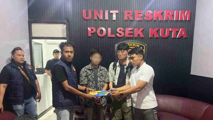 Suasana di ruang Unit Reskrim Polsek Kuta, terlihat sejumlah petugas kepolisian sedang mengamankan seorang pria tersangka (wajah disamarkan) mengenakan kemeja motif bunga.