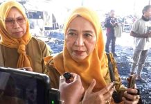 Baznas dan OPD Lotim Kompak Keroyok Penanganan Kebakaran Pringgabaya Dua pejabat wanita mengenakan seragam dinas cokelat dan jilbab kuning memberikan keterangan kepada wartawan di lokasi kebakaran pasar yang hangus.