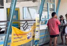 Bapenda Lombok Utara Gandeng BPN Mutakhirkan Data PBB Demi Kejar PAD 37 Miliar Loket pelayanan tiket pelabuhan dengan beberapa orang mengantre di depan jendela kaca, terdapat spanduk kuning informasi rute kapal di bagian depan.