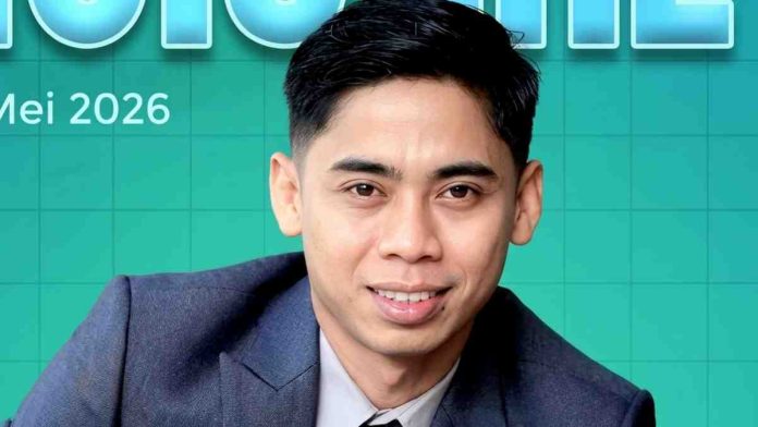 Foto close-up Sopyan Hakim mengenakan setelan jas formal biru tua dengan latar belakang desain grafis berwarna hijau toska bertuliskan Mei 2026.