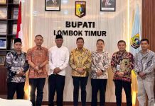 Jamkrida NTB Syariah Gandeng Pemda Lombok Timur Pacu PAD dan Ekonomi UMKM Bupati Haerul Warisin berdiri bersama jajaran direksi Jamkrida NTB Syariah di ruang kerja bupati, tampak kompak mengenakan kemeja batik dan peci hitam.