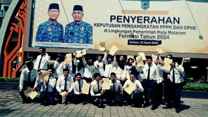 Sekelompok pegawai PPPK Kota Mataram berseragam putih hitam berfoto bersama sambil mengangkat dokumen surat keputusan di depan baliho besar bergambar Wali Kota dan Wakil Wali Kota.