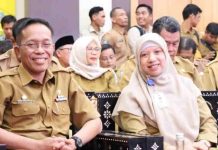 Pemkab Lombok Barat Serahkan LKPD Unaudited Tahun 2025 ke BPK RI Wakil Bupati Lombok Barat Hj. Nurul Adha mengenakan jilbab merah muda dan seragam dinas cokelat, duduk berdampingan dengan pejabat pria dalam sebuah acara resmi di aula gedung.