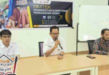 SRMA 38 Lombok Timur Perkuat Kompetensi Wali Asuh Lewat Bimtek Khusus Tiga orang pria duduk di meja narasumber dalam ruangan kelas. Pria di tengah berbicara menggunakan mikrofon dengan latar belakang spanduk bertuliskan Bimtek Peningkatan Kompetensi Pengasuhan Siswa.