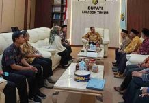 Bupati Haerul Warisin Komit Pertahankan Predikat Lotim Informatif Bupati Haerul Warisin duduk di kursi sofa putih memimpin pertemuan dengan delegasi KI NTB yang duduk berhadapan di ruang tamu pendopo kabupaten.