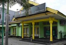Bank NTB Syariah Respons Cepat Laporan Nasabah di Cabang Dompu Tampak depan bangunan kantor Bank NTB Syariah KC Dompu berwarna hijau dengan aksen pilar kuning, dilengkapi papan nama besar di bagian atas serta pepohonan di halaman.