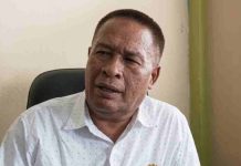 Beban Kerja Ganda Pengawas Sekolah Lombok Timur Capai Dua Kali Lipat Foto close-up wajah Islahul Muttaqin, seorang pria paruh baya mengenakan kemeja putih motif bintik-bintik, sedang memberikan penjelasan dalam sebuah sesi wawancara.