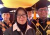 Dies Natalis ke-10 Poltekpar Lombok, Kurleni Ukar Tekankan Inovasi SDM Raden Kurleni Ukar mengenakan jilbab hitam berdiri di depan, didampingi jajaran pimpinan Poltekpar Lombok yang mengenakan toga wisuda lengkap dengan kalung medali.