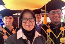 Dies Natalis ke-10 Poltekpar Lombok, Kurleni Ukar Tekankan Inovasi SDM Raden Kurleni Ukar mengenakan jilbab hitam berdiri di depan, didampingi jajaran pimpinan Poltekpar Lombok yang mengenakan toga wisuda lengkap dengan kalung medali.