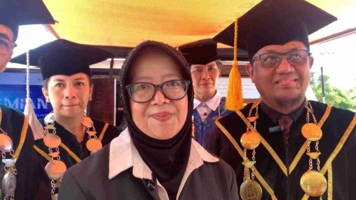 Raden Kurleni Ukar mengenakan jilbab hitam berdiri di depan, didampingi jajaran pimpinan Poltekpar Lombok yang mengenakan toga wisuda lengkap dengan kalung medali.