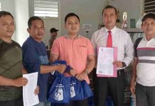 Disdag Lotim Tegaskan HPS Sembako Sesuai Survei Pasar dan Kawalan APH Seorang pria berbaju putih berbicara memegang mikrofon dengan latar belakang backdrop biru besar yang menampilkan foto tokoh nasional.